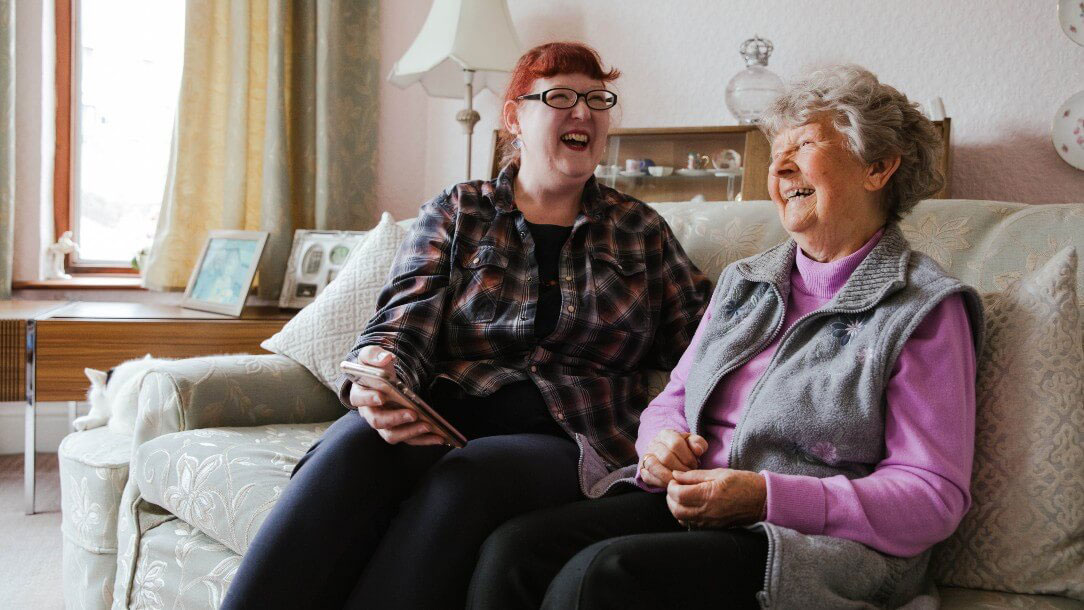 Photo of two women sitting on the sofa and talking